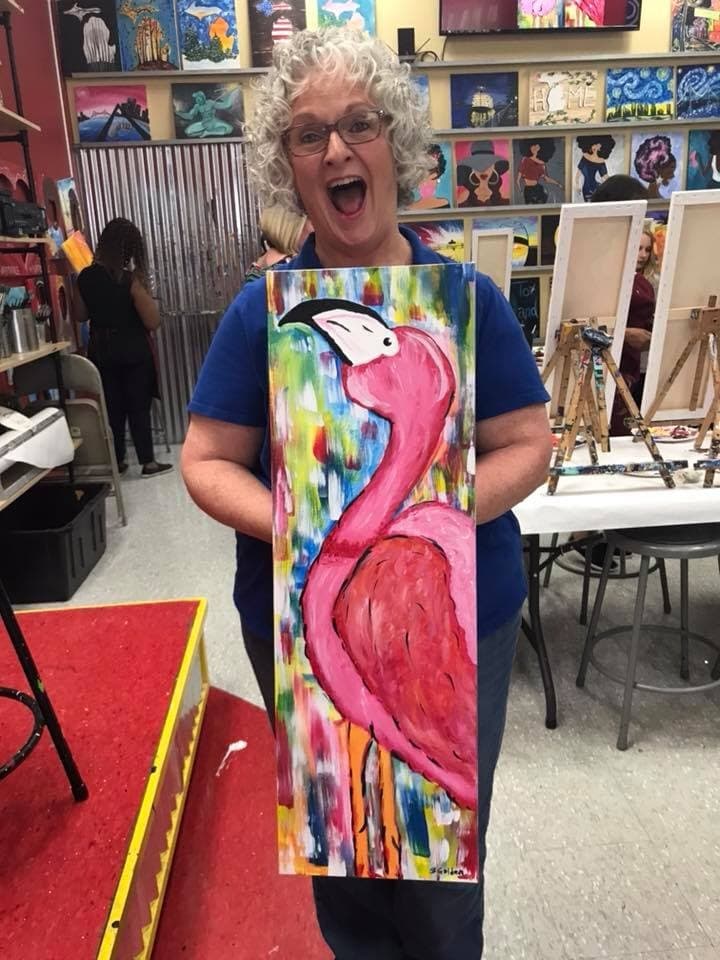 Bobbi Carlson Golden holding a colorful flamingo painting